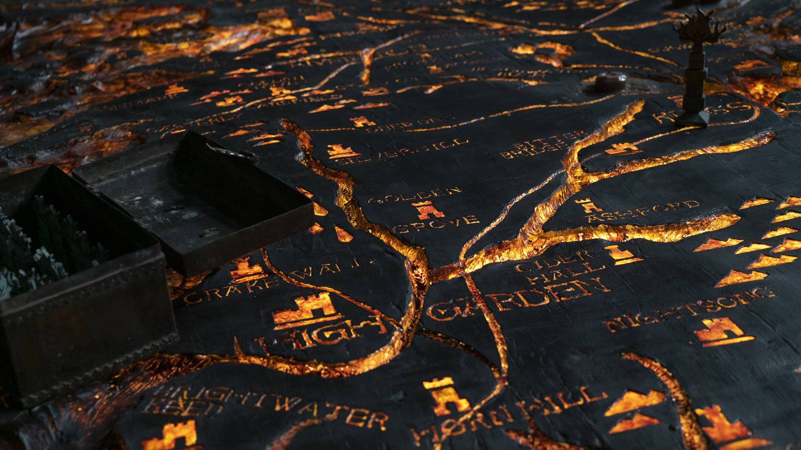 A close-up of the painted table in House of the Dragon, with rivers running red, almost like lava, through mnany locations written on the map.