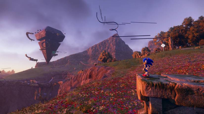 Sonic the Hedgehog, standing on a rocky ledge, gazes out at a field covered in flowers in Sonic Frontiers, with a series of floating rails, platforms, and an inverted pyramid like structure, in the background.