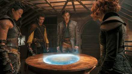 A grubby, battered D&D party (Michelle Rodriguez, Justice Smith, Chris Pine, and Sophia Lillis) gather around a glowing circular map in a scene from Dungeons & Dragons: Honor Among Thieves
