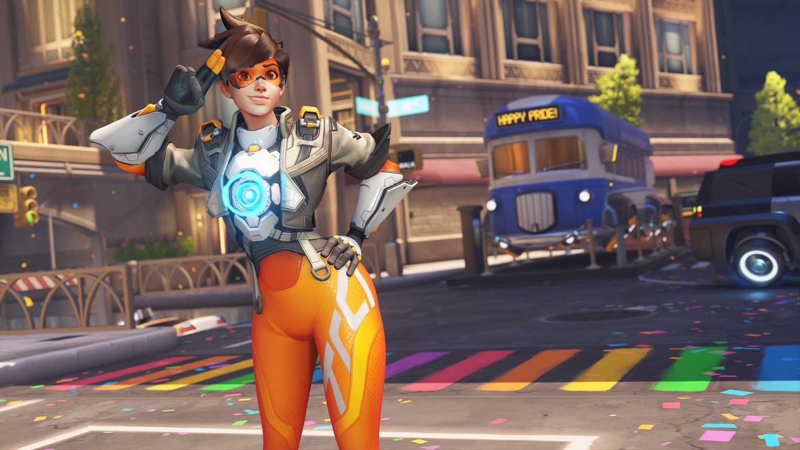 Tracer poses in front of a rainbow colored street crosswalk in the Midtown map from Overwatch 2