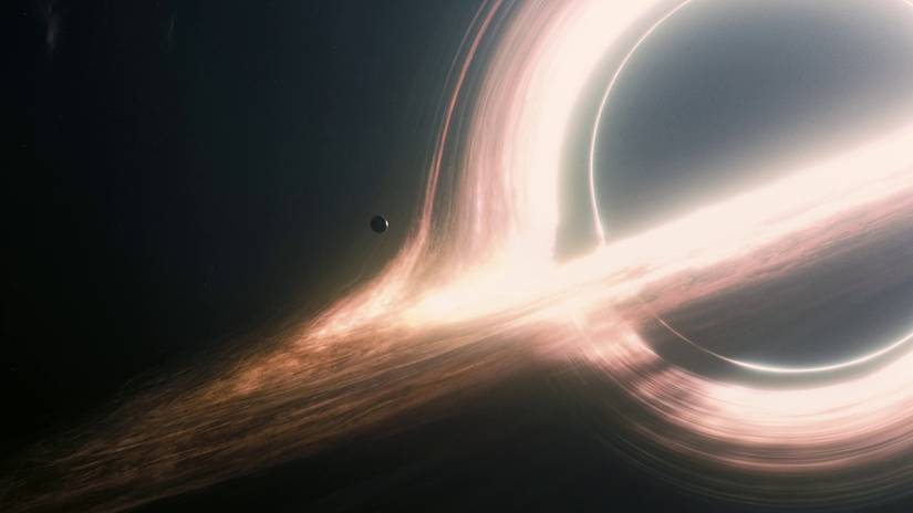 a wide shot of a tiny planetoid hovering at the event horizon of a massive black hole in Interstellar.