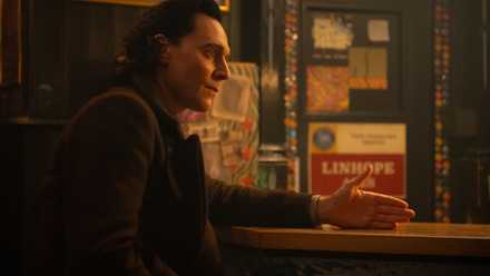 Loki (Tom Hiddleston) sitting at a counter