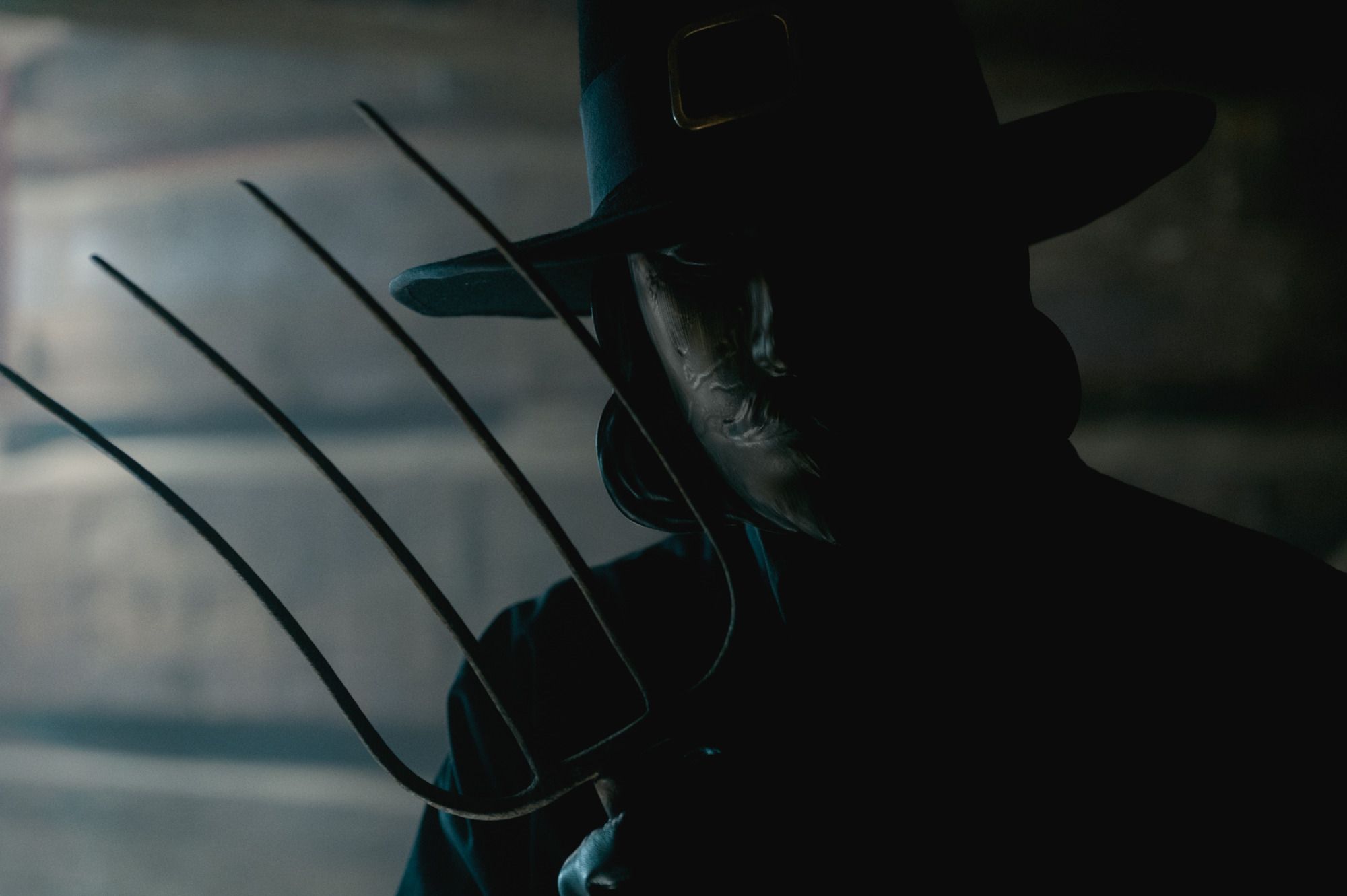 A man in a John Carver mask holds a pitchfork from the movie Thanksgiving