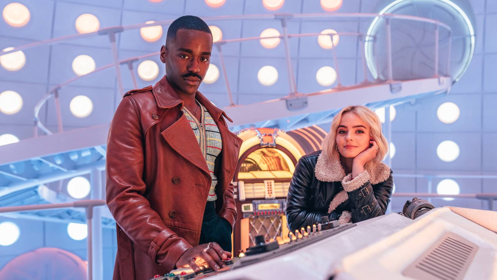 The Doctor poses suavely at the controls of his TARDIS while Ruby Sunday leans on the console and smirks in an image from the Doctor Who Christmas special.