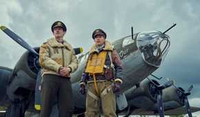 Callum Turner and Austin Butler stand befor Our Baby, one of the many il-fated Fortresses that co-star in Masters of the Air. It’s bristling with guns.