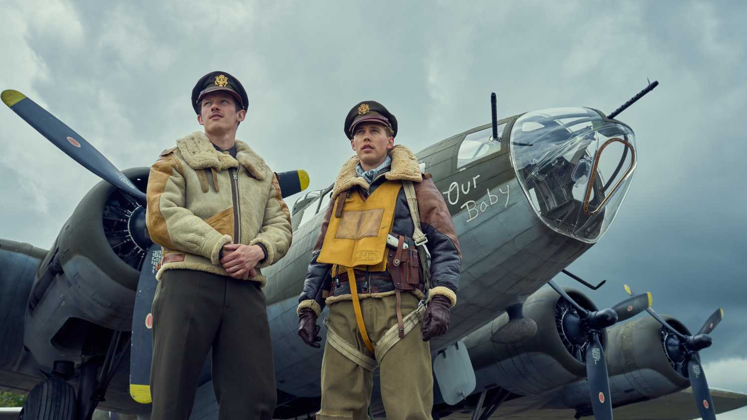 Callum Turner and Austin Butler stand befor Our Baby, one of the many il-fated Fortresses that co-star in Masters of the Air. It’s bristling with guns.