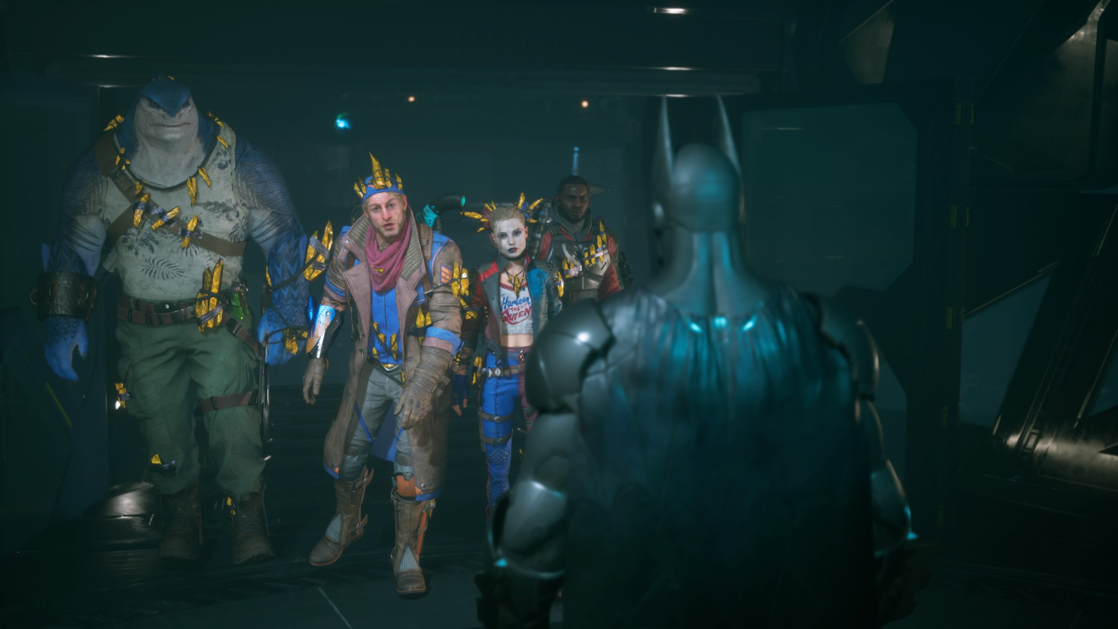 King Shark, Captain Boomerang, Harley Quinn, and Deadshot stare in disbelief at a hologram of Batman from Suicide Squad: Kill the Justice League.