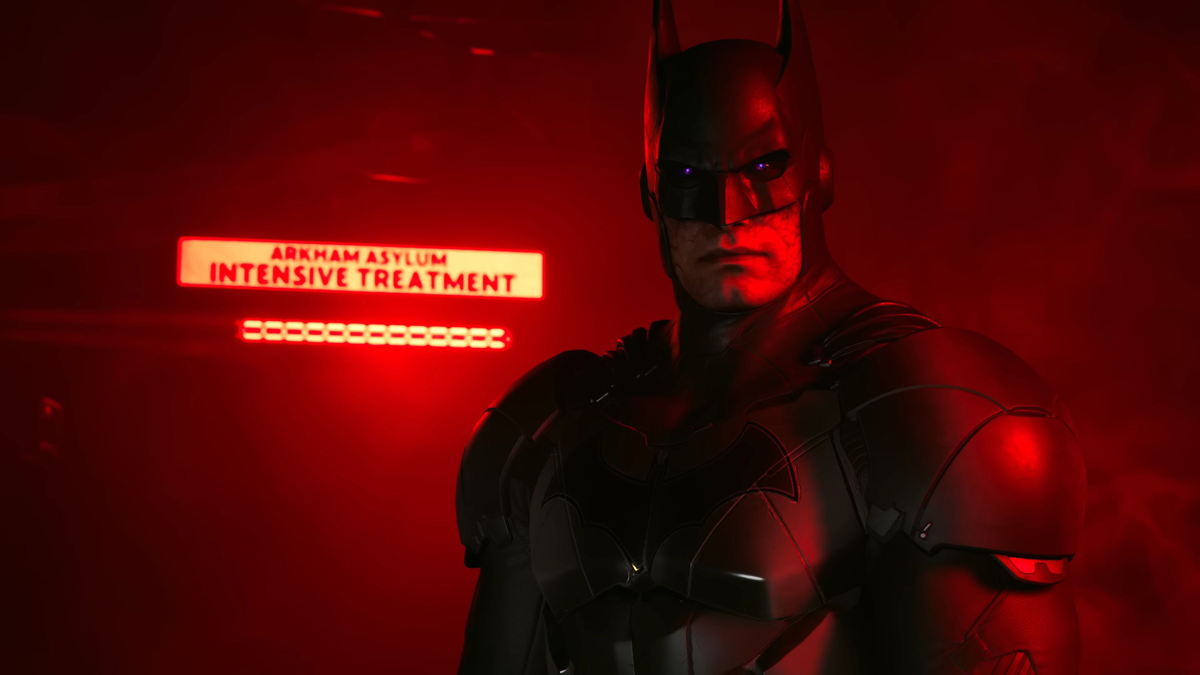 Evil Batman stands, with glowing eyes, in front of an Arkham Asylum intensive treatment sign, lit by dramatic red lighting in a still from Suicide Squad: Kill the Justice League
