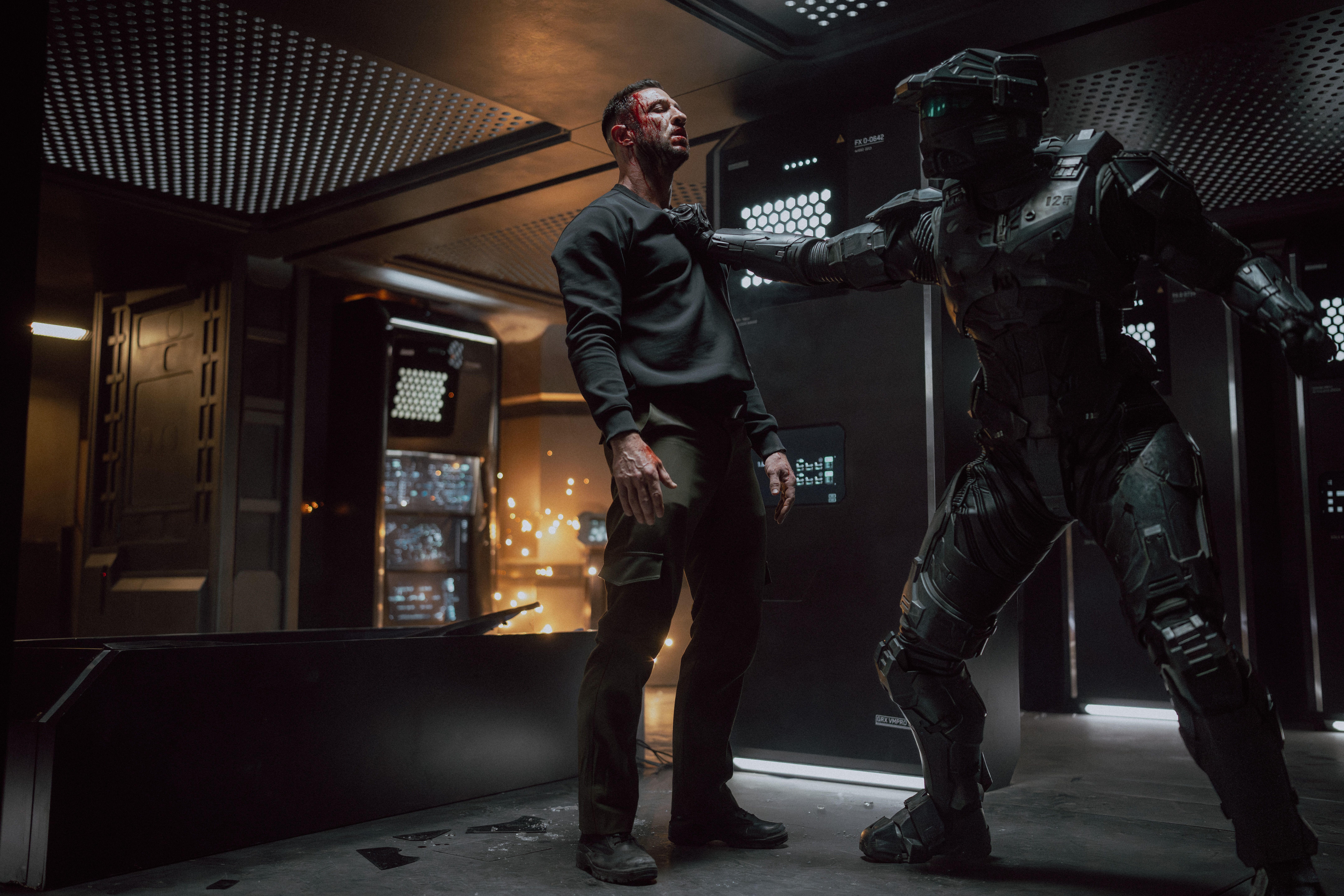 John (Pablo Schreiber) being held by Kai (Kate Kennedy) who is in her Spartan armor