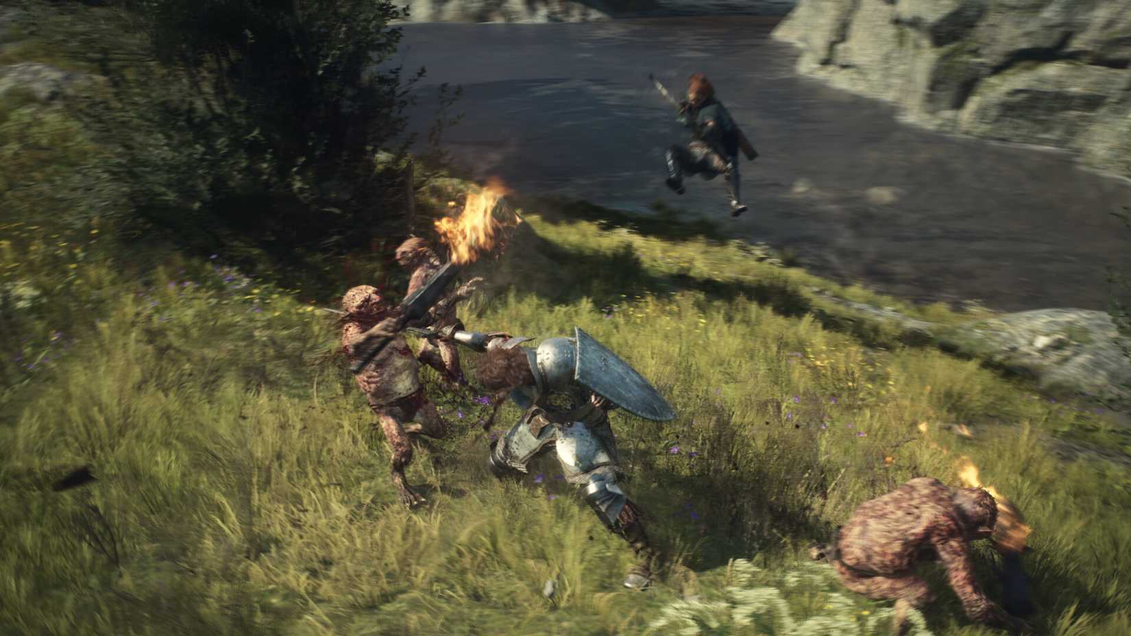 A warrior stabs a goblin in the throat by a river in Dragon’s Dogma 2. In the background, an archer aims and leaps