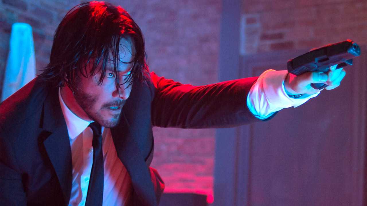 Keanu Reeves holds a gun as John Wick in John Wick.