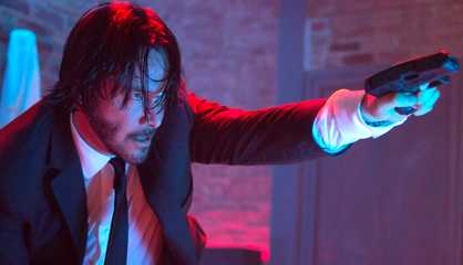 Keanu Reeves holds a gun as John Wick in John Wick.