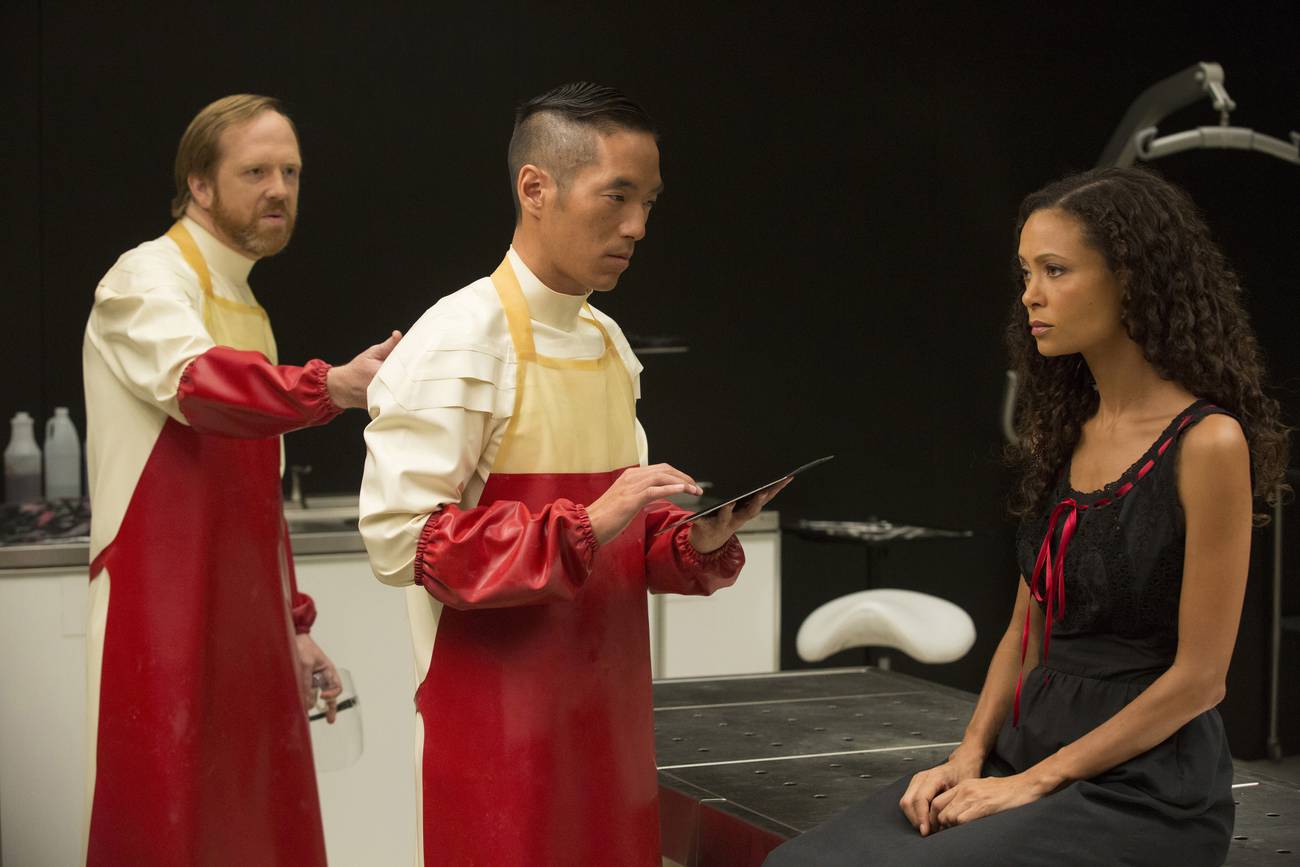 Westworld - Maeve sitting in the maintenance bay with two engineers