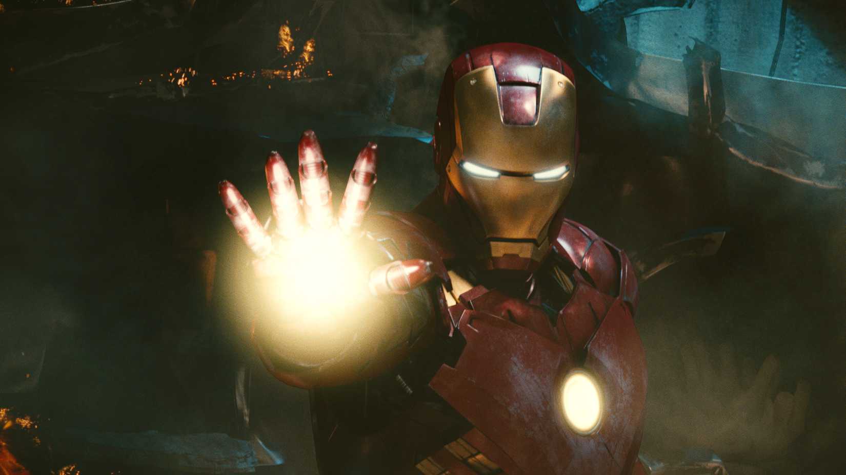 A still from Iron Man 2 in which Tony Stark is holding up his right hand charging a repulsor ray