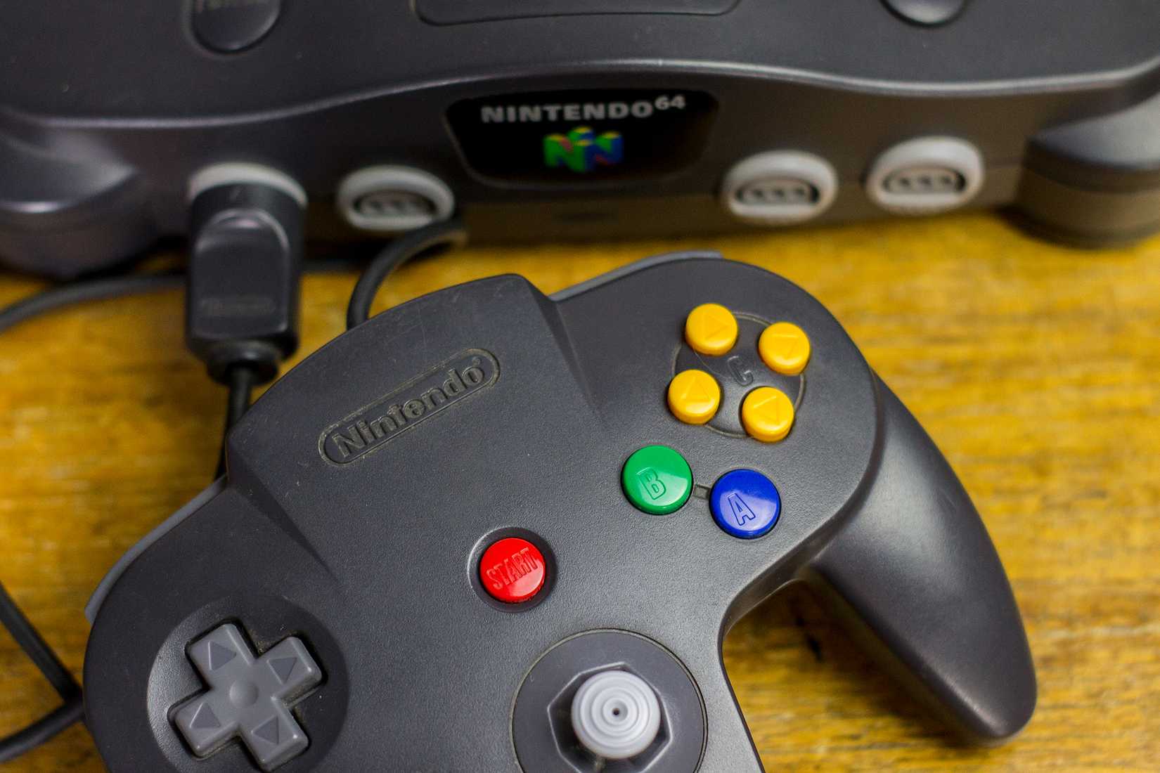 Nintendo 64 controller with console behind it