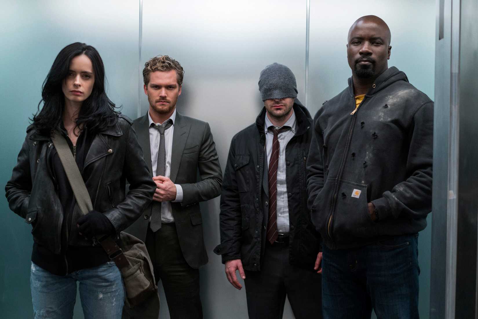 Jessica Jones, Iron Fist, Daredevil and Luke Cage stand in an elevator together in The Defenders.