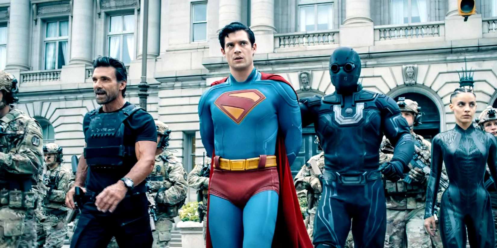 An image from James Gunn's 2025 film Superman. It depicts Superman, arms behind his back, getting arrested by guards in black tactical gear.