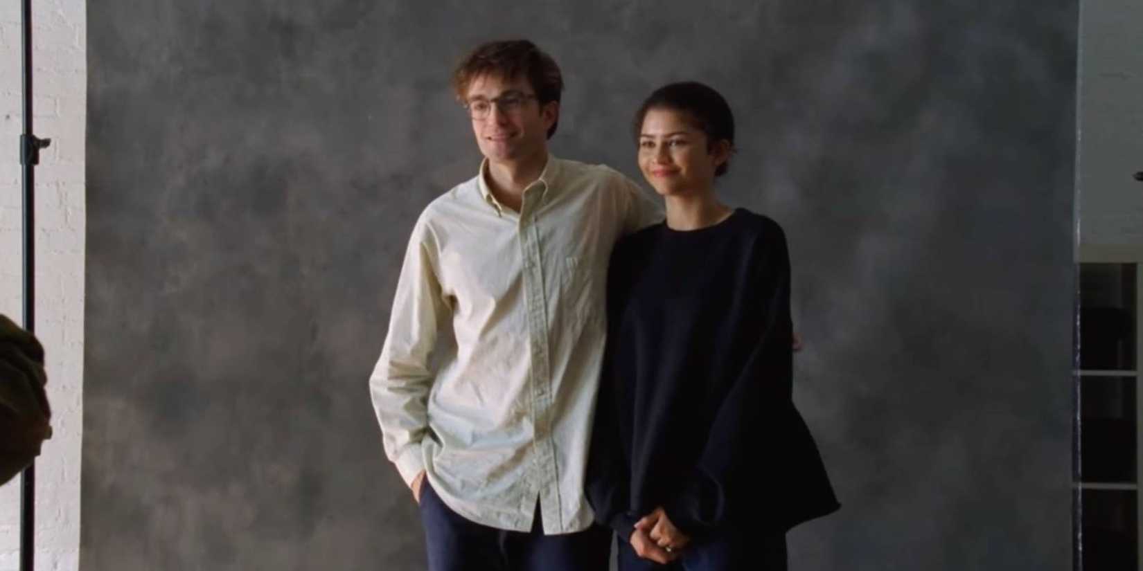 Still image from A24's The Drama showing Robert Pattinson and Zendaya's character pensively standing for a photoshoot together